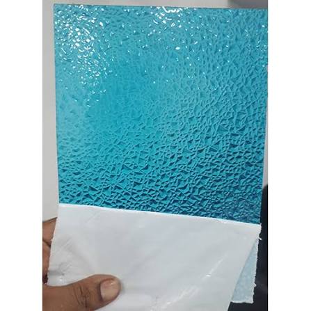 A textured turquoise blue sheet with a pebbled or embossed surface, held by a hand with a white backing paper visible along the bottom edge.